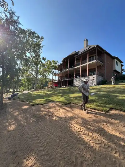 Freshly graded sand and soil base in front of a house with a large deck